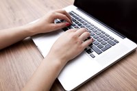 Close-up of woman typing on laptop