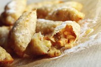 Fried apple pies dusted with powdered sugar.