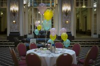 A table is decorated with party balloons in a hotel.