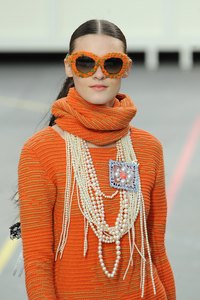A Chanel model piles on the pearls at Paris Fashion Week Womenswear in March 2014.