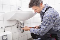 Man working on sink drain.