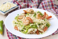 Shrimp served on a bed of pasta and zucchini ribbons topped with freshly grated parmesan cheese.