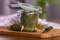 Brine should cover the tops of the cucumber pieces in the jars.