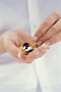 A woman is holding a variety of supplements.
