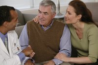 Two mature adults are talking to a doctor.