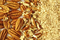 Close-up of pecans beside chopped pecans.