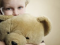 A boy holds his teddy bear.