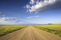 Calcium chloride controls weeds and dust that may spring up on a rural roadway.