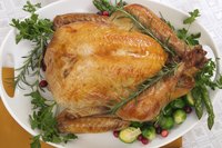 Roasted and garnished whole turkey on a large serving plate.