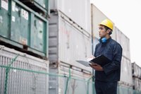 An employee taking inventory in a shipping yard.
