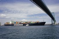A container ship is going under the bridge.