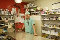 A veterinarian standing in an exam room with pharmaceuticals.