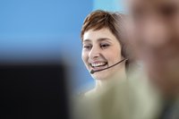 Smiling operator on the phone at a call center.