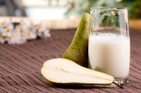 A pear smoothie with pear slices on the table.