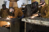 Welders are working in a shop.