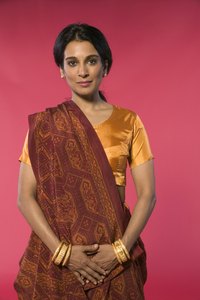 A saree blouse is worn underneath the saree wrap, which goes around the lower half of the body and over the shoulders.