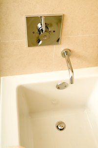 Remove the spout and faucet handles to lift up the old bathtub.