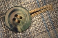 Threads in four-hole buttons may be sewn parallel or crossed.