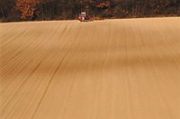 A field's surface is firmed by a cultipacker.