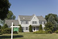 Exterior of a house with a 'For Sale' sign