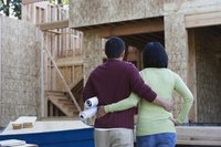 A couple is standing out front of their house under construction.