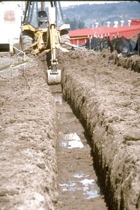 A backhoe removes soil with precision.