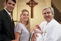 Parents and a young baby standing near a pastor.
