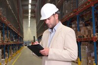 A manager does inventory at a huge warehouse.
