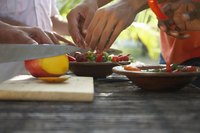 A close-up of Brazilians making fresh salads and salsas at an outdoor table.