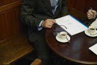 Two businessmen having a discussion at a cafe table.