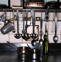 Increase your storage space in a galley kitchen by hanging utensils from rails.