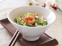 A salmon salad with greens, cucumber, garlic and sesame seeds.