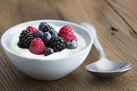 A bowl of yogurt with fruit on top.