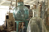 A close-up of large glass vessels and other items at a flea market.