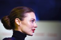 Model Miranda Kerr pairs a navy blue turtleneck with simple diamond studs.