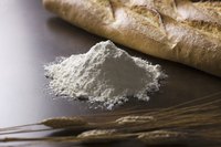 Pile of bread flour beside freshly baked loaf