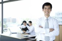 A HR manager poses in front of two employees in a modern office
