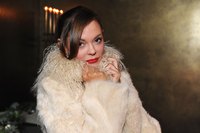A celebrity wearing a designer coat posing for a photo.