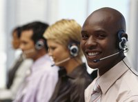 Smiling man wearing a headset at a call center.