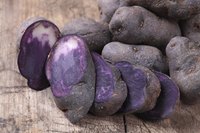 A sliced purple potato on a cutting board.