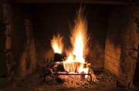 A fire burns instide a brick fireplace.