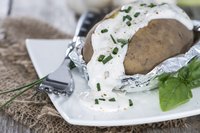 Top baked potatoes with sour cream and chives.