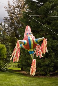 Children typically take turns hitting a pinata while wearing a blindfold.