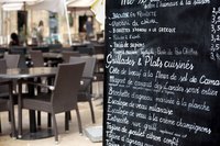 Restaurant menu with chairs and tables in background.