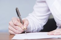 Man using a pen to sign a letter.