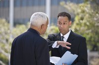 Two businessmen are discussing a letter in their hands.
