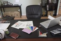 Office desk covered in personal belongings and work.