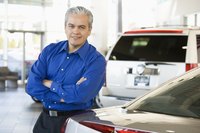 A car salesman is standing in his showroom.