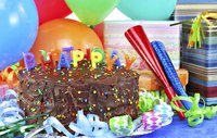 A birthday cake with streamers, balloons, noise makers and presents.