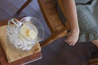 A woman relaxing on the porch with a pitcher of lemon water.